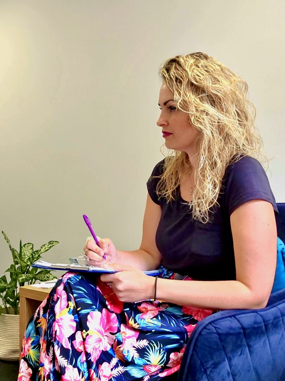 anxiety therapist - OCD therapist - therapist neat you in Morden sitting in the therapy room taking notes